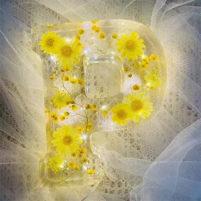 Håndlavede bogstaver med blomster og LED-lys