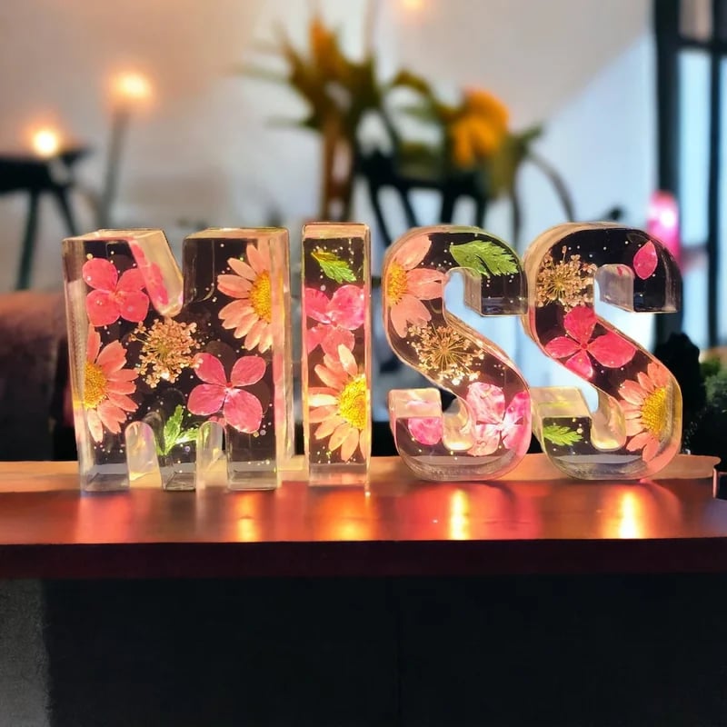 Håndlavede bogstaver med blomster og LED-lys